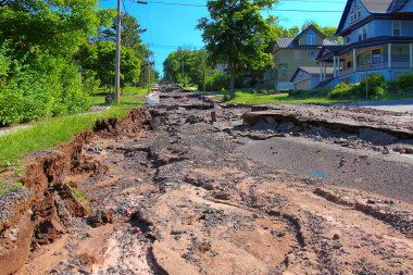 Houghton, Michigan, USA - June 18, 2018: Intense storm rainfall and flash flooding in June of 2018 caused property damage and completely washed out Agate Street in the town of Houghton, Michigan. clipart