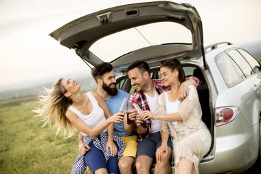 Araba kataloğumuzda doğa gezisi sırasında oturan gençlerin Grup