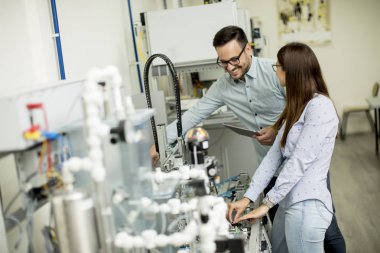 Robotik laboratuarda çalışan öğrencilerin genç çift portresi