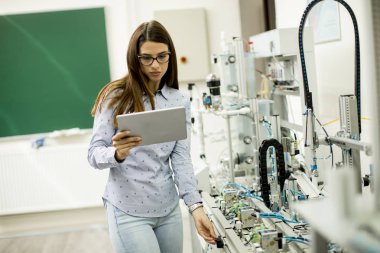 Dijital tablet ile bir laboratuvarda Robotik ve Genç kız öğrenci portresi standları