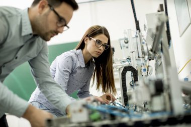 Robotik laboratuarda çalışan öğrencilerin genç çift portresi