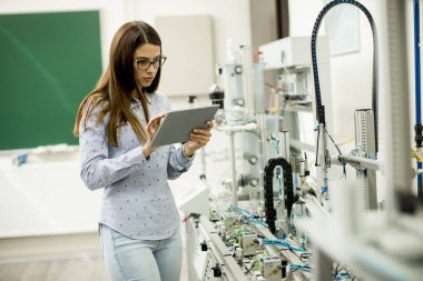 Elektronik atölyesinde dijital tablet ile genç ve güzel kadın