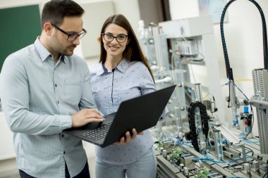 Robotik laboratuarda çalışan öğrencilerin genç çift