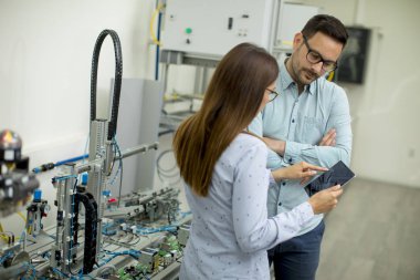 Robotik laboratuarda çalışan öğrencilerin genç çift portresi