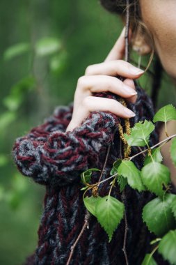 Modern kazak giyen ve parkta poz genç kadın