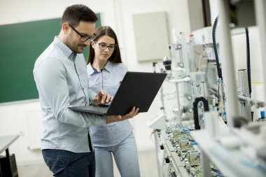 Robotik laboratuarda çalışan öğrencilerin genç çift