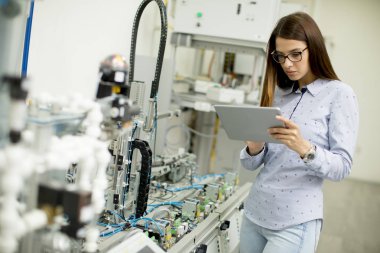 Dijital tablet ile bir laboratuvarda Robotik ve Genç kız öğrenci portresi standları