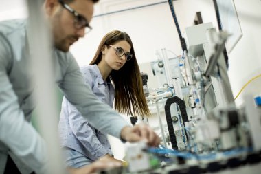 Robotik laboratuarda çalışan öğrencilerin genç çift portresi