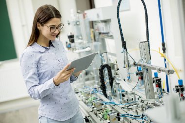 Laboratuvarda dijital tablet kullanarak kadın elektronik mühendisi portresi