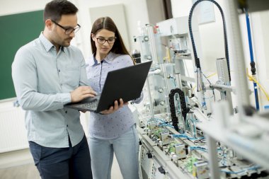Robotik laboratuarda çalışan öğrencilerin genç çift