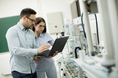Laptop ile robotik laboratuarda çalışan öğrencilerin genç çift