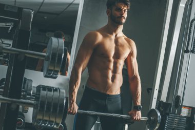 Güçlü ve yakışıklı bir genç adam dumbbells ile egzersiz yaparak portresi