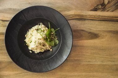 Bir ahşap masa kompozisyon üzerinde uygun gem ve levisticum kereviz risotto, üstten görünüm