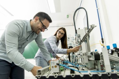 Robotik laboratuarda çalışan öğrencilerin genç çift portresi