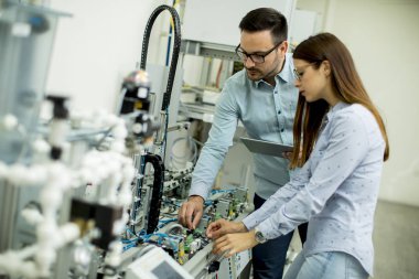 Robotik laboratuarda çalışan öğrencilerin genç çift portresi