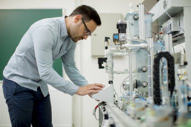 Elektronik atölyesinde yakışıklı genç