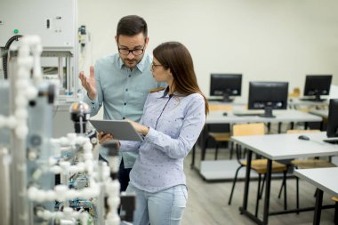 Robotik laboratuarda çalışan öğrencilerin genç çift