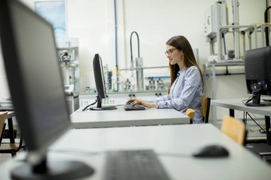 Genç ve güzel kadın sınıfta masası tarafından öğrenme