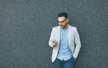 Formal giyim istimal hareket eden telefon açık duvar tarafından genç işadamı