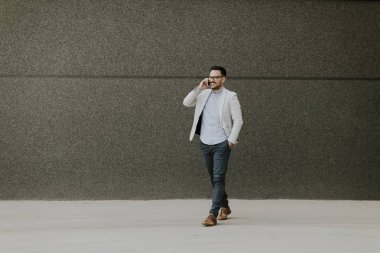 Formal giyim istimal hareket eden telefon açık duvar tarafından genç işadamı