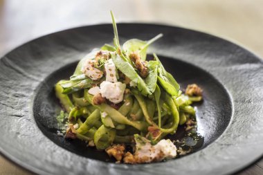 Yakın bakış ev yapımı makarna, ıspanaklı ve keçi peynirli plaka üzerinde