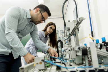 Robotik laboratuarda çalışan öğrencilerin genç çift portresi