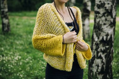 Modern kazak giyen ve parkta poz genç kadın