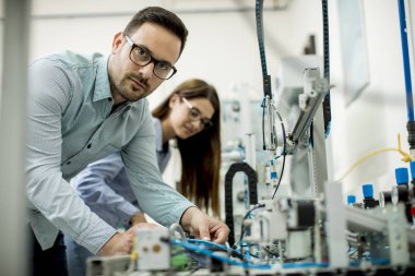 Robotik laboratuarda çalışan öğrencilerin genç çift