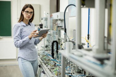 Elektronik atölyesinde dijital tablet ile genç ve güzel kadın