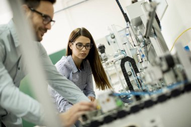 Robotik laboratuarda çalışan öğrencilerin genç çift portresi