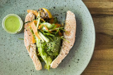 Tabakta sebze ile haşlanmış somon, üstten görünüm