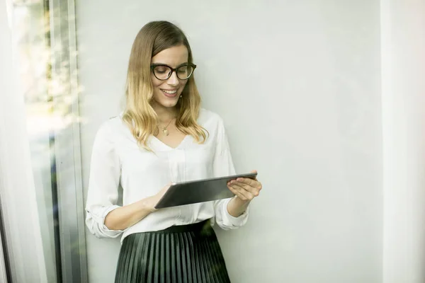 年轻有吸引力的女经理 致力于数字平板电脑同时站在现代办公 — 图库照片