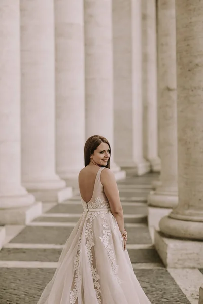 美丽的年轻新娘在婚礼礼服在梵蒂冈柱廊 — 图库照片