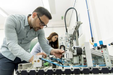Robotik laboratuarda çalışan öğrencilerin genç çift