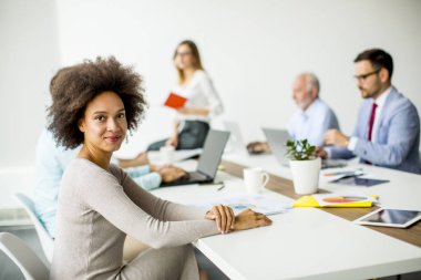 Siyah ve beyaz iş arkadaşlarınızla toplantı ofiste kameraya bakarak gülen