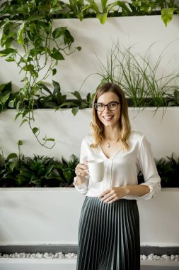 Kupa ayakta ofiste olan kadın portresi