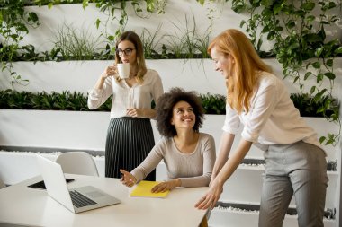 Çalışma veri ve modern ofisindeki sunmak neşeli profesyonel çok ırklı kadınlar