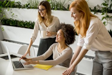 Çalışma veri ve modern ofisindeki sunmak neşeli profesyonel çok ırklı kadınlar