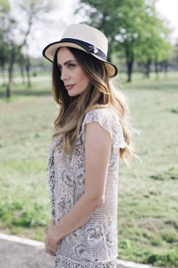 Parkta güneşli yaz gününde poz şapka ile güzel bir zarif kadın portresi