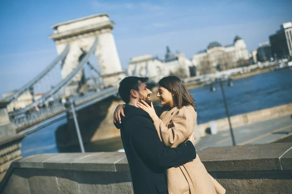 Young happy attractive couple in love hugging with background of the magnificent view of Budapest, Hungary