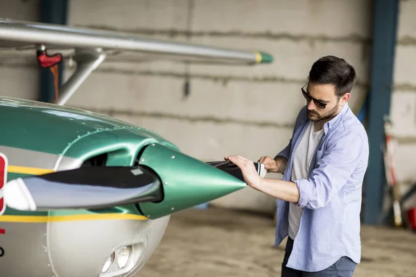 Jovem Piloto Bonito Verificando Avião Hangar — Fotografia de Stock