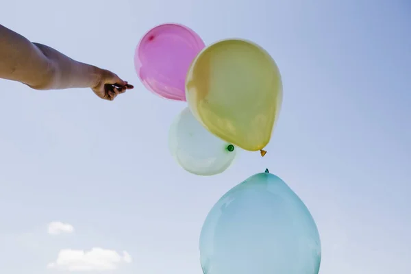 Montones Globos Colores Mano Contra Cielo Azul —  Fotos de Stock