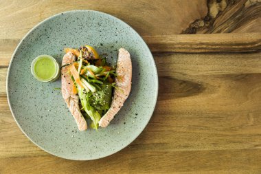 Tabakta sebze ile haşlanmış somon, üstten görünüm