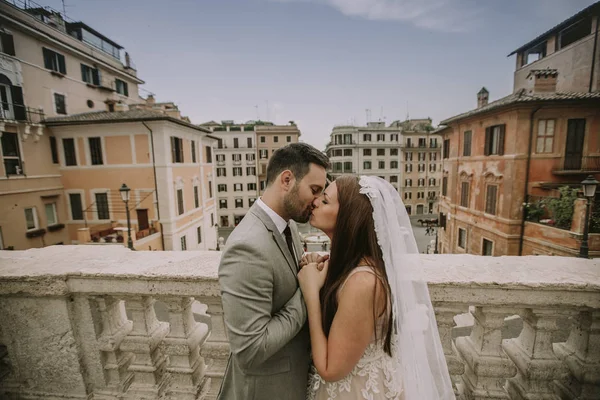 Genç çekici yeni evli çift ile güzel ve antik mimari planda Roma'da poz