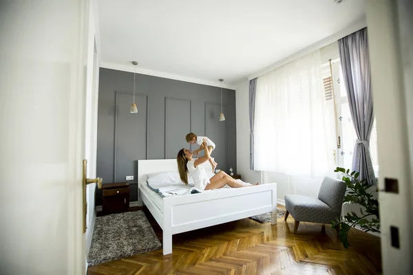 Oung Mãe Com Seu Filho Bonito Cama Quarto — Fotografia de Stock