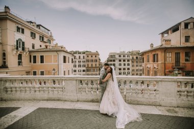 Genç çekici yeni evli çift ile güzel ve antik mimari planda Roma'da poz