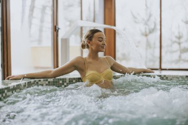 Genç ve güzel kadın kapalı köpük banyosu havuzunda rahatlatıcı