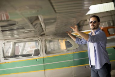 Yakışıklı genç pilot uçuş öncesi hangarda onun ultralight uçak kontrol