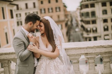 Genç çekici yeni evli çift ile güzel ve antik mimari planda Roma'da poz