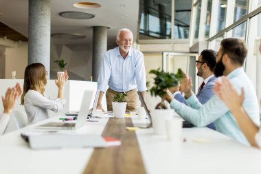 Üst düzey patron genç meslektaşları modern ofis için bir toplantı tutan